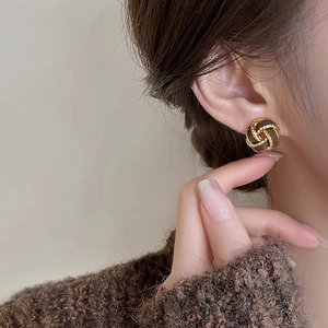 Retro gold twisted rope earrings with brown round center on model for autumn winter