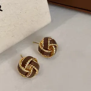 Macro shot of retro brown enamel twist stud earrings with gold plated rope details