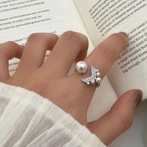 Gros plan d'une bague queue de poisson ajustable en argent avec perles et cristaux