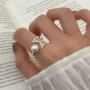 Vue détaillée d'une bague ajustable en or avec perles et design queue de poisson en cristal