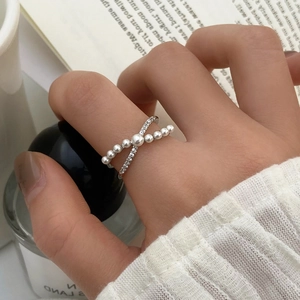 Détail d'une bague croisée en argent avec perles dégradées et accents de zircons brillants