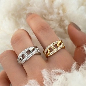 Close-up of gold and silver pig nose anchor chain rings with sparkling micro-pave crystals