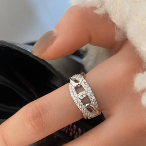 Detail of silver-colored chain ring with sparkling pavé zircons on model finger