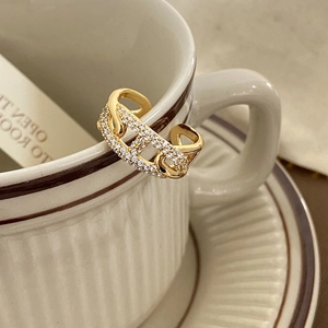 Close-up of a gold chain-link open ring featuring sparkling micro-pave zircon crystals