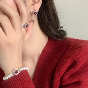 Vue rapprochée d'un ensemble de bijoux rouge rubis avec perles sur un mannequin