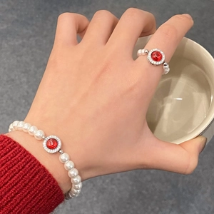 Détail d'un ensemble de bijoux en perles blanches avec pierres précieuses rouges