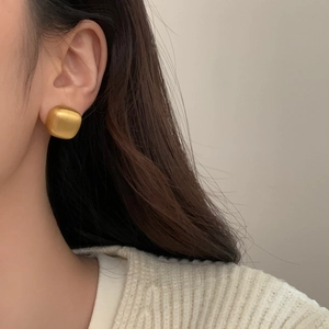 Minimalist geometric square stud earrings in brushed gold finish worn by model