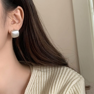 Minimalist square geometric brushed metal stud earrings on a female model