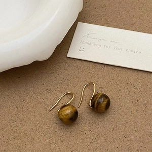 Détail des boucles d'oreilles vintage en œil de tigre avec crochets dorés élégants