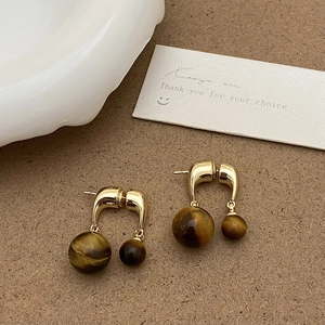 Vue détaillée de boucles d'oreilles vintage en pierre d'oeil de tigre avec finition dorée