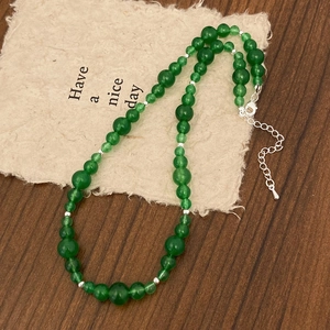 Détail d'un collier de perles vertes avec espaceurs argentés et fermoir mousqueton chic