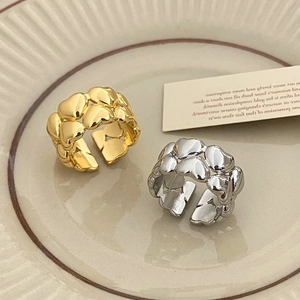 Anelli vintage a doppio cuore in finitura oro e argento su un piatto di ceramica