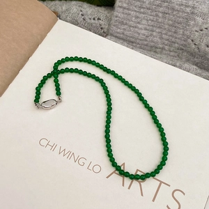 Detailed macro view of a green chalcedony beaded necklace with a silver oval clasp