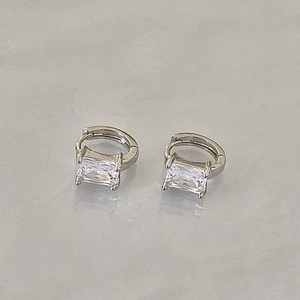 Dettaglio di orecchini a cerchio in argento con grandi zirconi cubici trasparenti a taglio rettangolo