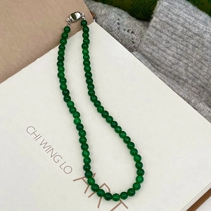 Detail of green chalcedony beaded necklace with silver clasp on art book backdrop