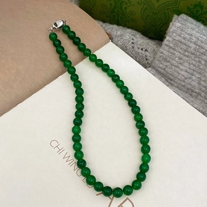 Close-up of green chalcedony beaded necklace with elegant silver metal clasp detail