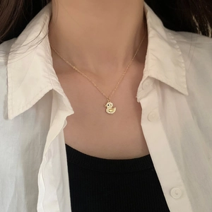 Dettaglio della collana a papera dorata con micro-zirconi sul collo della modella