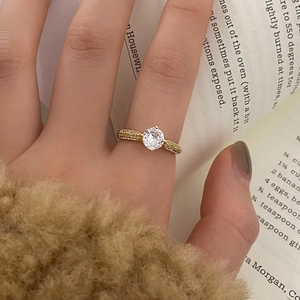 Detail of a gold-plated ring with micro-paved cubic zirconia and a four-prong center stone