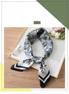 Detail of blue paisley silk scarf with contrast border and elegant floral background