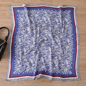 Close-up of vintage paisley pattern on navy silk scarf with decorative borders