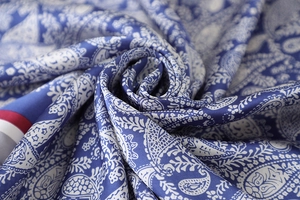 Macro shot of royal blue paisley pattern silk scarf with elegant glossy fabric folds