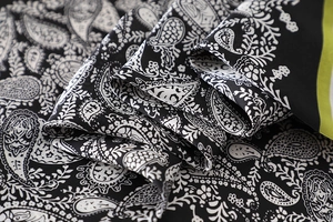 Detail of silk-like paisley scarf with lime green borders and soft draped texture