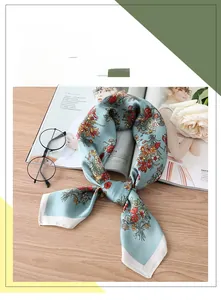Detaillierte Nahaufnahme eines blauen Seidenschals mit Blumenmuster auf einem Holztisch