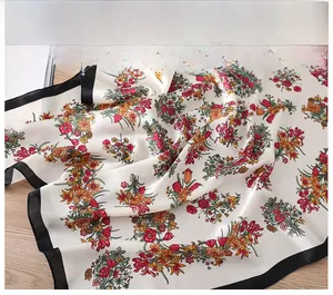 Nahaufnahme der feinen schwarzen Kantennaht an einem Seidenschal mit Blumenmuster