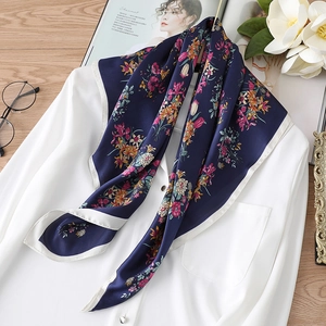 Seidenschal mit Blumenmuster in Dunkelblau auf weißem Hemd mit Lifestyle-Hintergrund