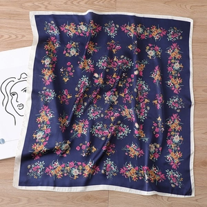 Marineblaues Seidenimitat-Vierecktuch mit Blumenmuster und weißem Rand auf Holzgrund