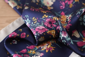 Makroaufnahme von dunkelblauem Blumenseidenschal mit glatter Satin-Stofftextur
