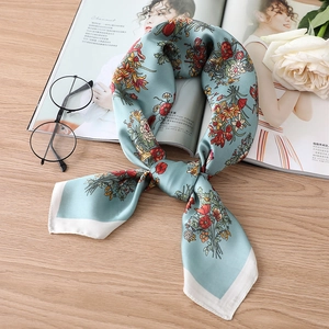 Eleganter Seidenschal mit Blumenmuster in Minzgrün auf einem Magazin mit Accessoires