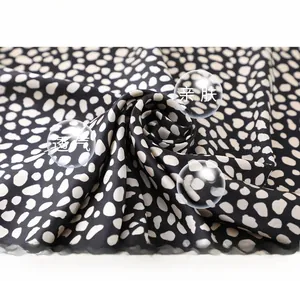 Détail d'un foulard en soie synthétique à motif léopard avec texture brillante