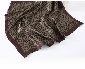 Gros plan détaillé du foulard en soie imprimé léopard vert foncé au fini brillant