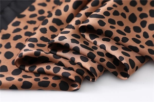 Gros plan sur un tissu satiné à imprimé léopard avec texture lisse et motif animal
