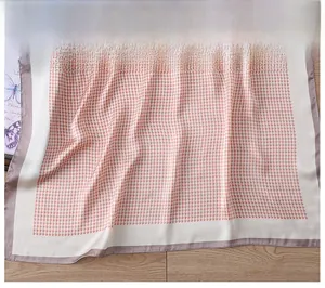 Detailed view of pink houndstooth silk scarf featuring premium stitched edges and soft texture
