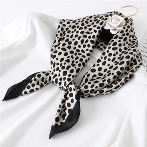 Élégant foulard en soie à motif léopard noir et blanc sur un cintre doré avec rose