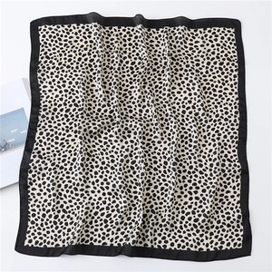 Gros plan détaillé d'un foulard en soie à imprimé léopard avec finition lisse et bords noirs