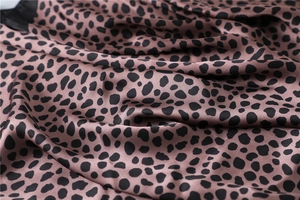 Gros plan du tissu d'un foulard en soie léopard rose avec texture et éclat doux