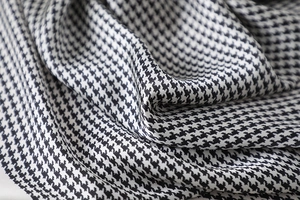Close-up of houndstooth silk scarf showing premium satin texture and elegant fabric folds