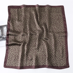 Gros plan du foulard en soie imprimé léopard avec texture lisse et couleurs vintage