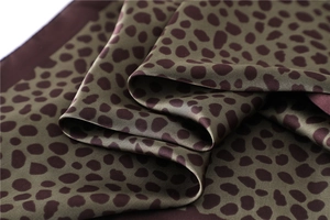 Gros plan du foulard en satin léopard montrant une texture soyeuse et un éclat lisse