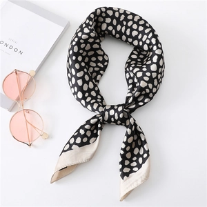 Carré de soie élégant à pois beige sur fond noir avec une texture douce et brillante