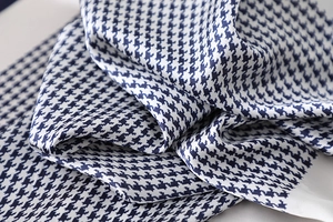 Close-up of navy and white houndstooth silk scarf with elegant satin texture and gloss