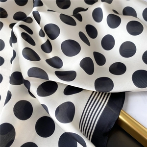 Détail d'un foulard en soie style Hepburn à pois avec bordures rayées élégantes