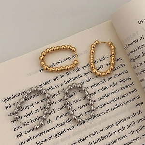 Ensemble de boucles d'oreilles perlées dorées et argentées sur une page de livre