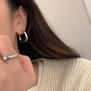 Ensemble créoles C en argent poli et bague minimaliste porté par un mannequin femme