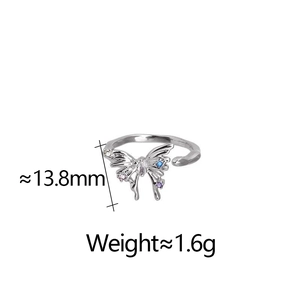 Détail d'une bague papillon argentée avec zircons colorés et ailes ajourées