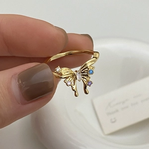 Gros plan détaillé sur une bague papillon dorée ornée de zircons colorés élégants