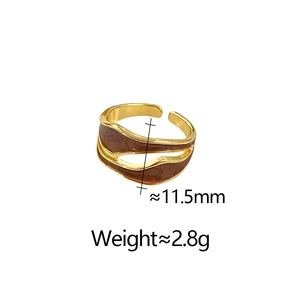 Detail view of wavy gold open ring showing 11.5mm width and brown enamel finish